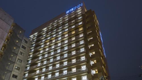 a tall building with a blue sign on top of it at Toyoko Inn Nagano-eki Higashi-guchi in Nagano