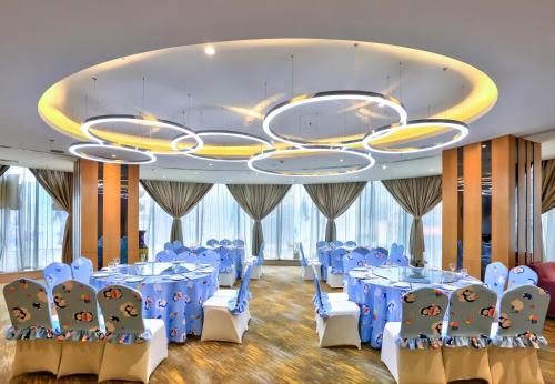 a banquet hall with blue tables and chairs and a chandelier at Holiday Inn Express City Centre Dalian by IHG in Dalian