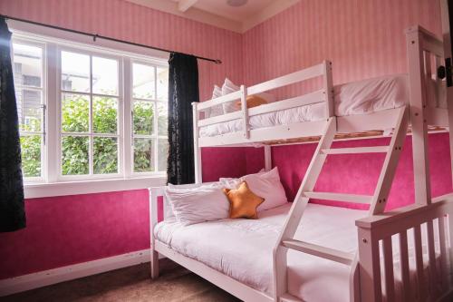 a bedroom with two bunk beds and a window at Victorian Designs - Spacious Home in Rotorua Central in Rotorua