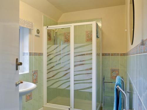 a shower with a glass door in a bathroom at Green Hedges in Budleigh Salterton