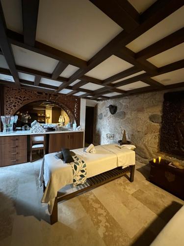 a bedroom with a bed and a stone wall at Hotel Lindo Ajijic Bed & Breakfast in Ajijic