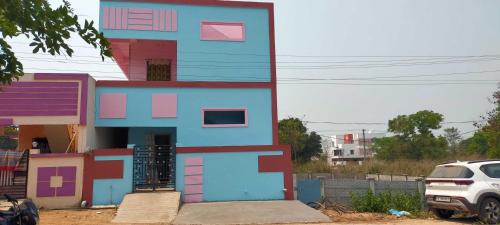 a house that is painted blue and pink at OYO HOME 81185 Srinivas Service Home in Rājahmundry