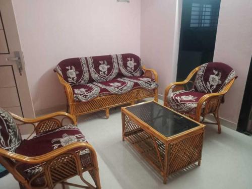 a living room with chairs and a couch and a table at OYO HOME 81185 Srinivas Service Home in Rājahmundry