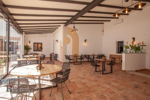 a large room with tables and chairs and windows at Hotel Rural el Turuñuelo 