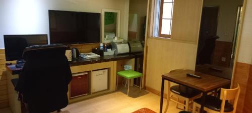 a room with a desk with a computer and a green stool at Design T Motel in Ulsan