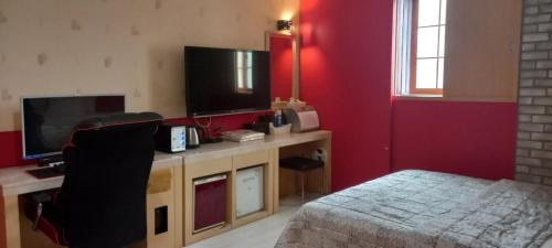 蔚山的住宿－Design T Motel，一间卧室配有一张床和一台平面电视