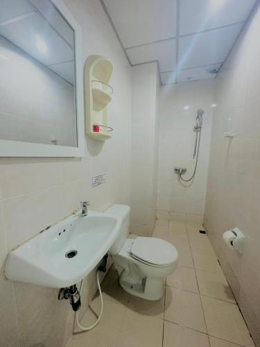a white bathroom with a sink and a toilet at Cocoon Omaya Guest House in Patong Beach