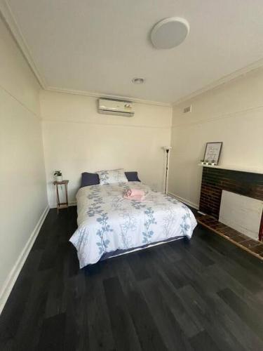 a bedroom with a bed and a fireplace at Sandown Springvale close to shop/station in Springvale