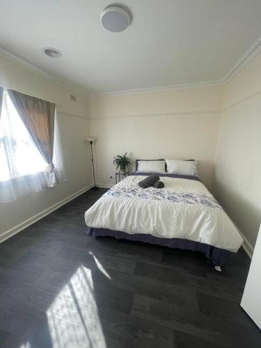 a bedroom with a large bed and a window at Sandown Springvale close to shop/station in Springvale
