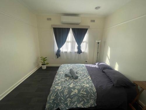 a bedroom with a bed with a gray object on it at Sandown Springvale close to shop/station in Springvale
