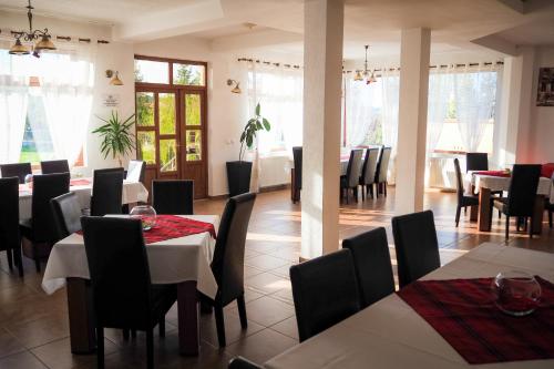 a dining room with tables and chairs and windows at Pensiunea Riffelt in Bran