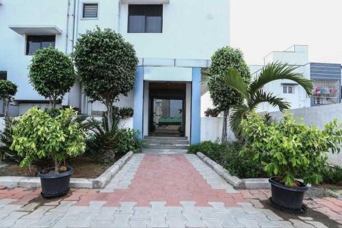 a brick walkway with trees in front of a building at OYO 81146 Hotel Prashant Villa in Gwalior