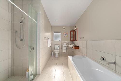 uma casa de banho com uma banheira, um WC e um lavatório. em The Lakehouse - Taupo em Taupo