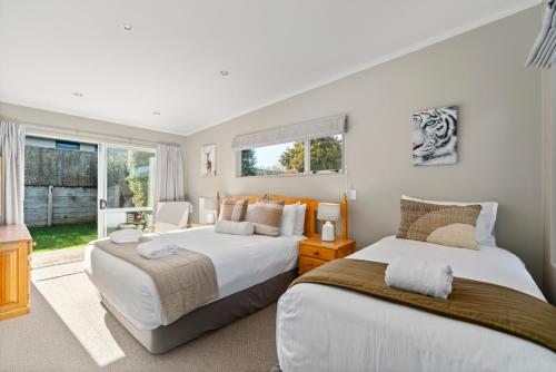 a bedroom with two beds and a window at The Lakehouse - Taupo in Taupo