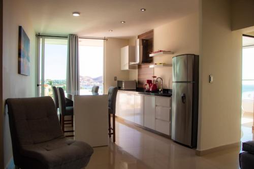eine Küche mit einem Kühlschrank und einem Tisch mit Stühlen in der Unterkunft Suites Rubí - Las Mejores vistas de San Carlos in San Carlos