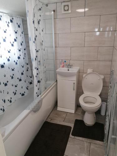 a bathroom with a toilet and a sink and a shower at Home of maximum relaxation/rest in Gillingham