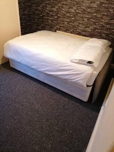 ein kleines Bett in einem Zimmer mit Ziegelwand in der Unterkunft Home of maximum relaxation/rest in Gillingham