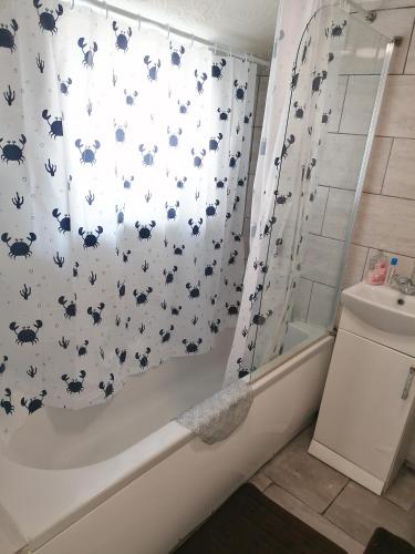 a bathroom with a shower curtain with bats on it at Home of maximum relaxation/rest in Gillingham