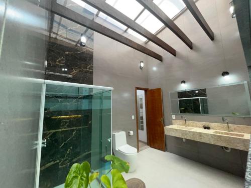 y baño con ducha acristalada y lavamanos. en Duplex em Guarapari com piscina privativa!, en Guarapari