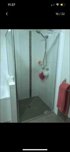 a shower with a glass door in a bathroom at Private Room in Shared Accommodation in Redcliffe