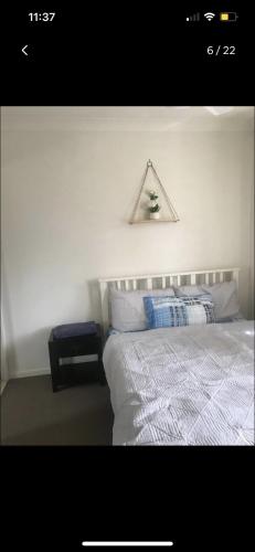 a bedroom with a white bed with a triangle shapedigunigunigunigun at Private Room in Shared Accommodation in Redcliffe