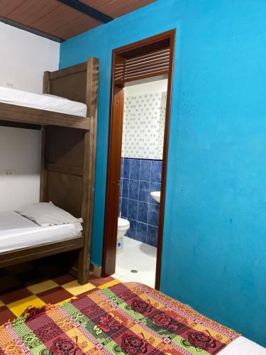 a room with two bunk beds and a bathroom at Havana Hostel Cali & Dance School in Cali