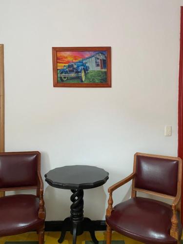 two chairs and a table with a table and two chairs at Havana Dance School & Hostel in Cali