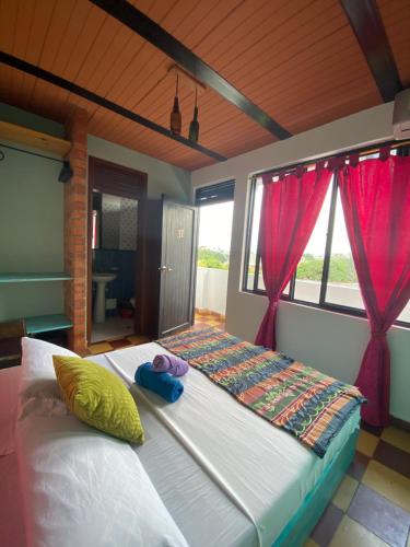 a large bed in a room with red curtains at Havana Dance School & Hostel in Cali