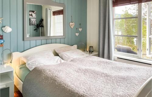 1 dormitorio con cama blanca y espejo en Amazing Home In Bverfjord With Wifi And 2 Bedrooms, en Bø