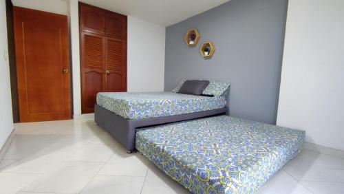 2 Betten in einem Zimmer mit Tür in der Unterkunft Apartamento con vista al embalse in Guatapé