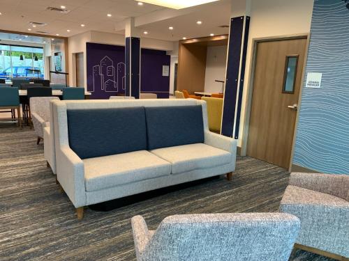 a couch in a waiting room with tables and chairs at Holiday Inn Express & Suites - Courtenay - Comox by IHG in Courtenay