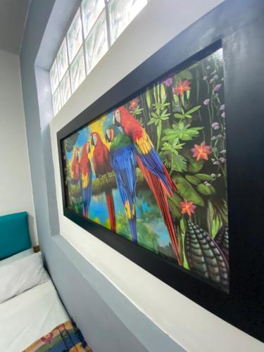 a large painting of parrots on a wall at Havana Dance School & Hostel in Cali