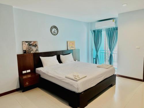 a bedroom with a bed with a clock on the wall at Cokoon Deva Patong Hotel in Patong Beach