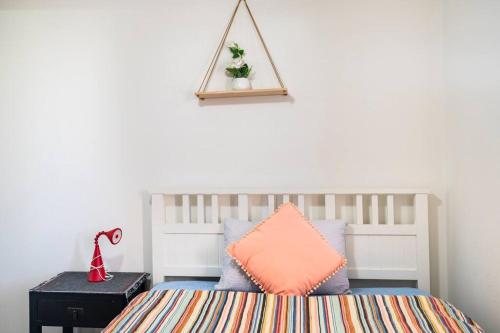 um quarto com uma cama com uma almofada laranja em Private Room with Separate Bath in Shared Accommodation em Redcliffe