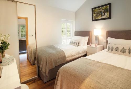ein Hotelzimmer mit 2 Betten und einem Spiegel in der Unterkunft Nos Da in Pencoed