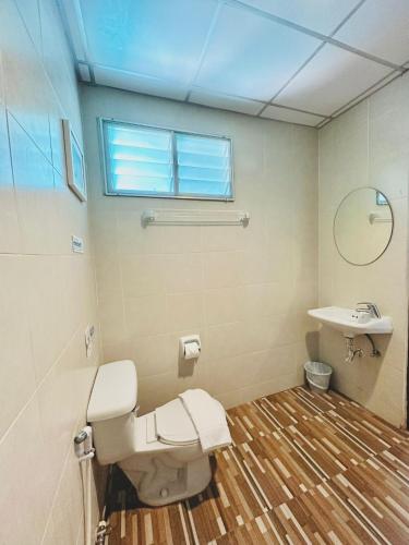 a bathroom with a toilet and a sink at Cokoon Deva Patong Hotel in Patong Beach