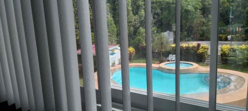 a view of a swimming pool from a window at Camiguin Lanzones Resort in Mambajao