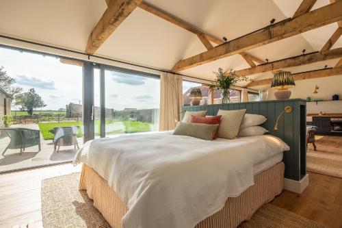 a bedroom with a large bed and a large window at The Goat Shed in Thompson