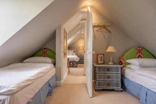Schlafzimmer im Dachgeschoss mit 2 Betten und Flur in der Unterkunft Field Piece Cottage in Burnham Market