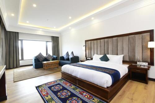 a hotel room with a large bed and a couch at Hotel Barath Ladakh in Leh