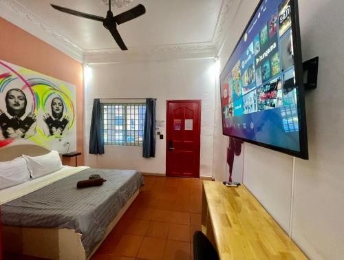 um quarto com uma cama e uma televisão de ecrã plano em The Funky Village em Siem Reap