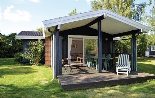 a gazebo with chairs and a table in a yard at Holiday Home Strandkrogen Ix in Dronningmølle
