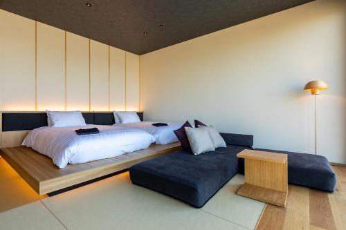 um quarto com 2 camas e um sofá em The358 SORA em Fukuoka