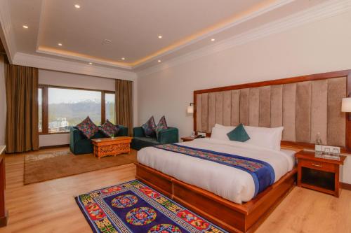 a hotel room with a bed and a living room at Hotel Barath Ladakh in Leh