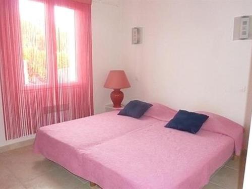 een slaapkamer met 2 bedden met roze lakens en een lamp bij Maison Saint-Pierre-d'Oléron, 4 pièces, 6 personnes - FR-1-246A-239 in Saint-Pierre-dʼOléron