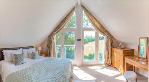 a bedroom with a bed and a large window at Luxurious 3 Bedroom New England Style Villa - Trewhiddle V8 in St Austell