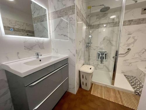 une salle de bain blanche avec un lavabo et une douche dans l'établissement Appartement à Saint-Cyprien avec Terrasse, Parking et Ascenseur - 5 couchages - FR-1-225D-191, à Saint-Cyprien