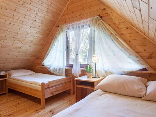 a bedroom with two beds in a wooden cabin at Spacious and comfortable holiday houses close to the beach, Pobierowo in Pobierowo