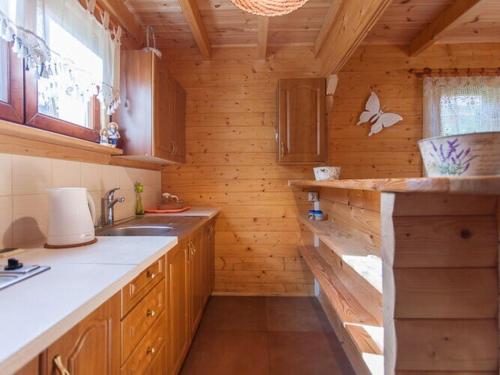 a kitchen with wooden walls and wooden cabinets and a sink at Spacious and comfortable holiday houses close to the beach, Pobierowo in Pobierowo