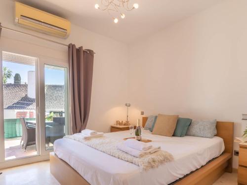een witte slaapkamer met een groot bed en een raam bij Villa Marina - Puerto Banus Apartment in Marbella